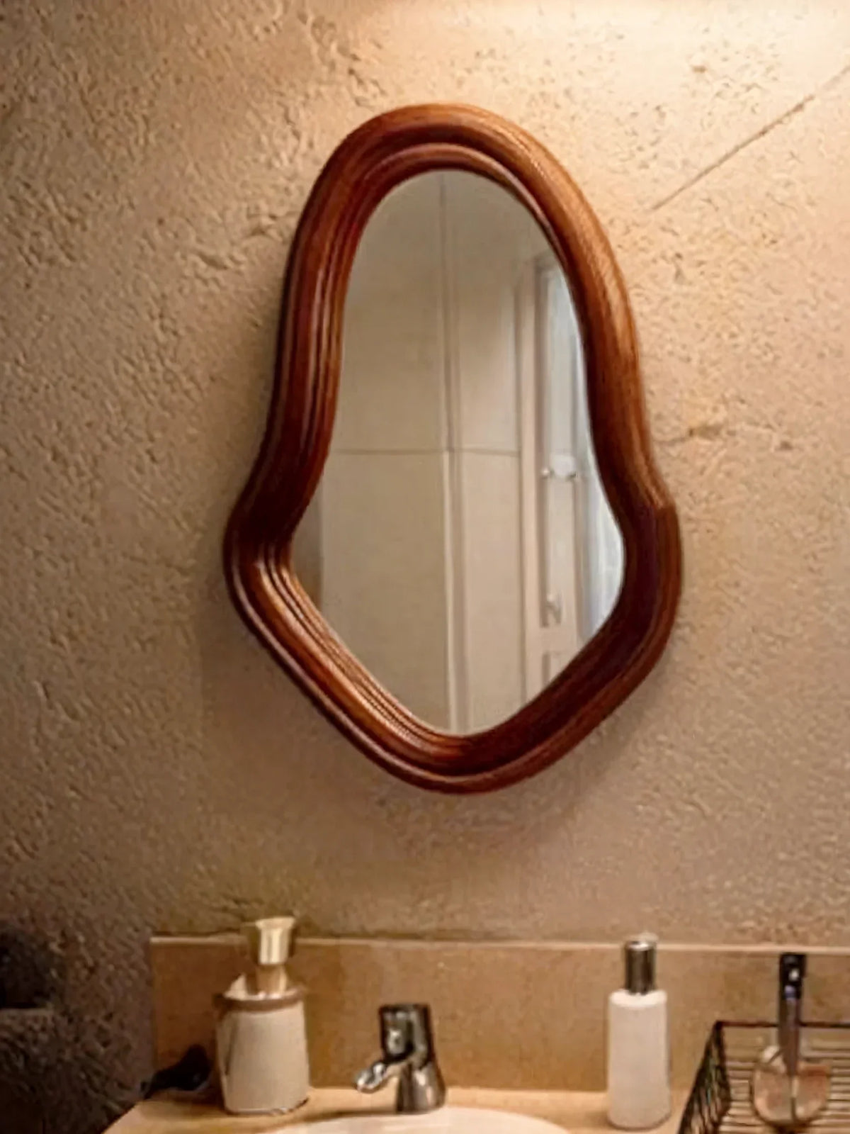Bathroom interior with textured wall, organic wood frame mirror, and modern sink decor