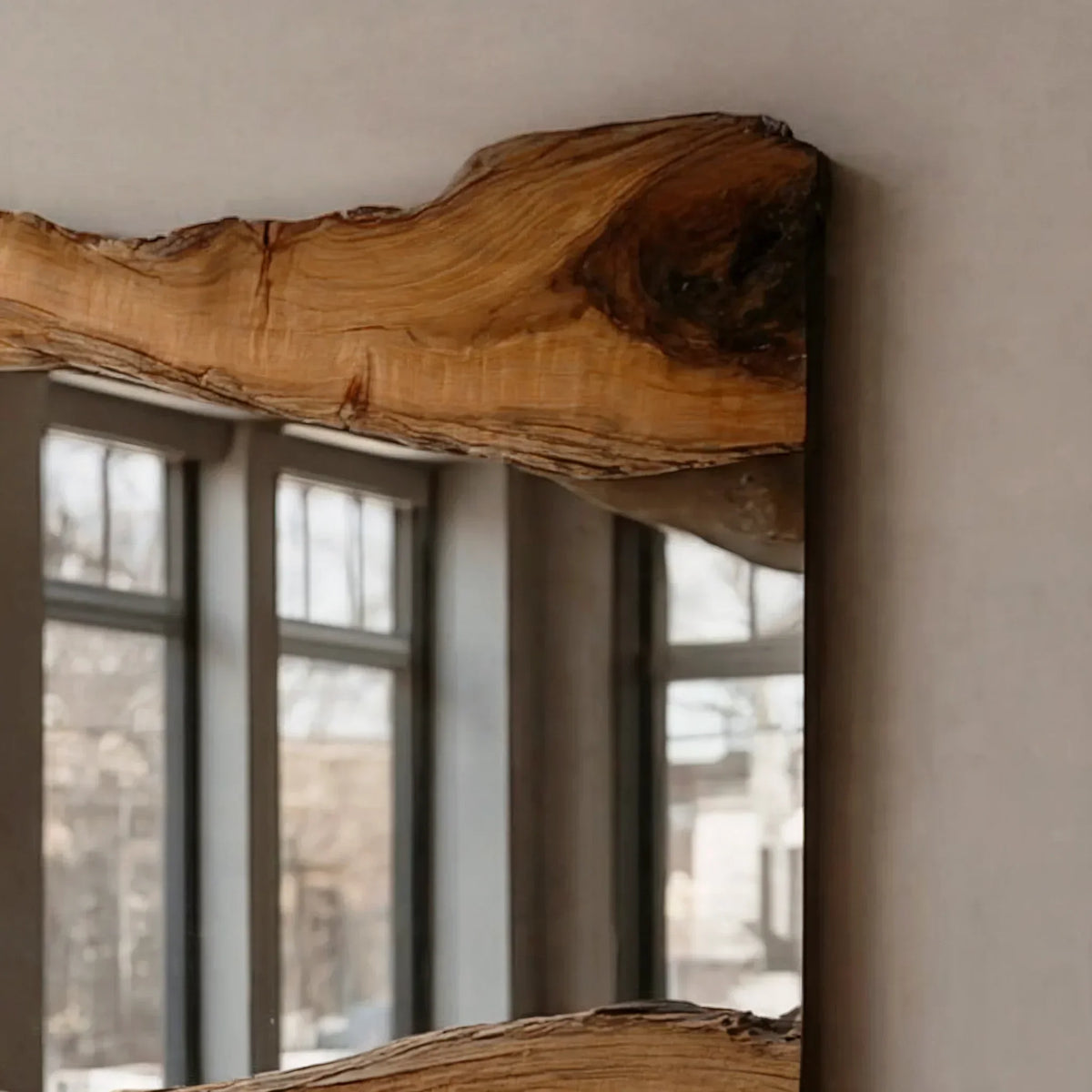 Close-up of a live edge wood-framed mirror with natural grain, modern interior background.