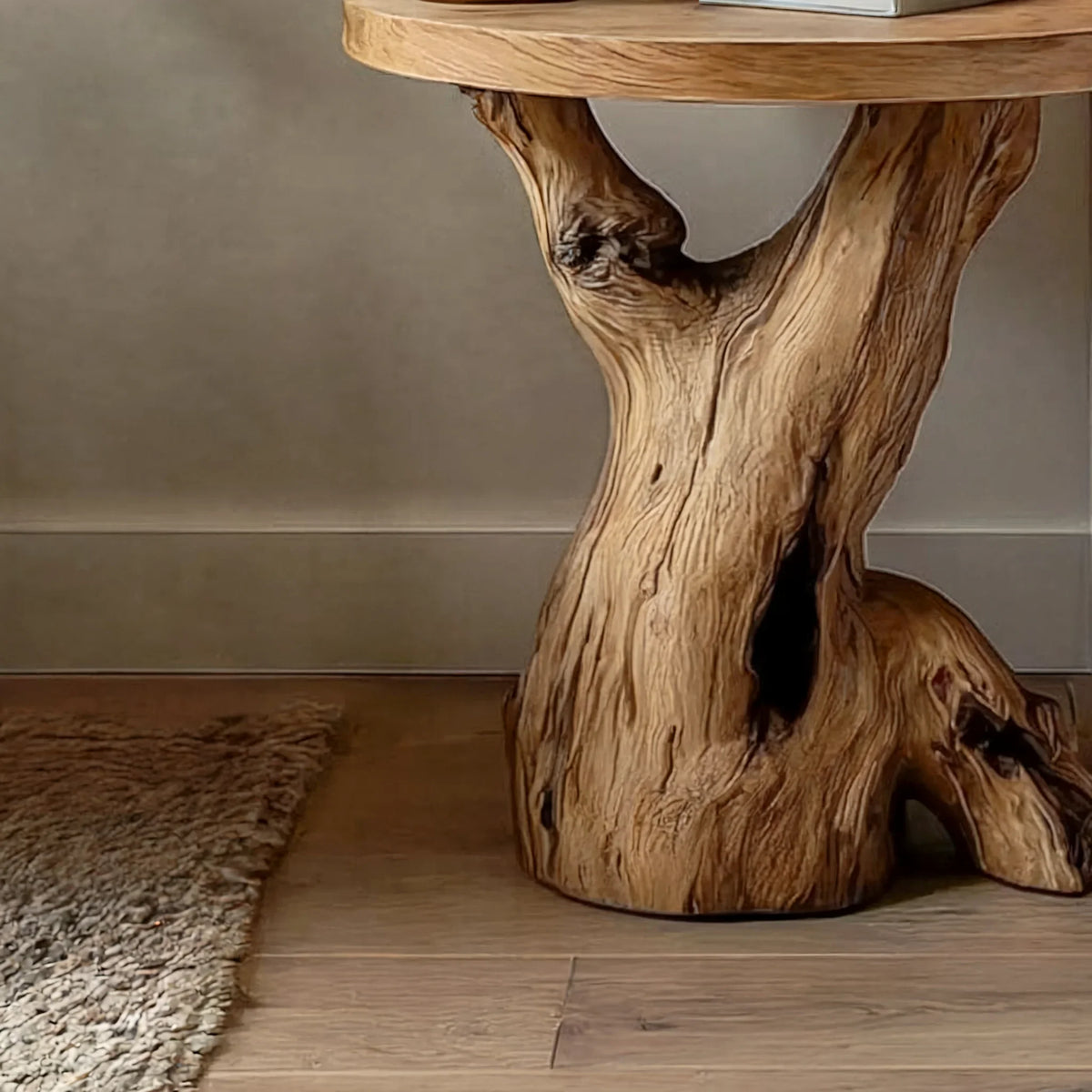 Close-up of a unique live edge solid wood table with a natural tree trunk base