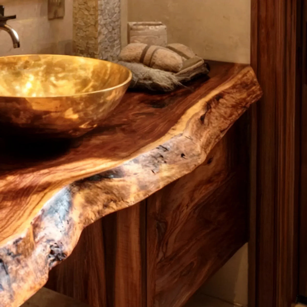 Luxurious bathroom vanity with a live edge wood countertop and gold vessel sink