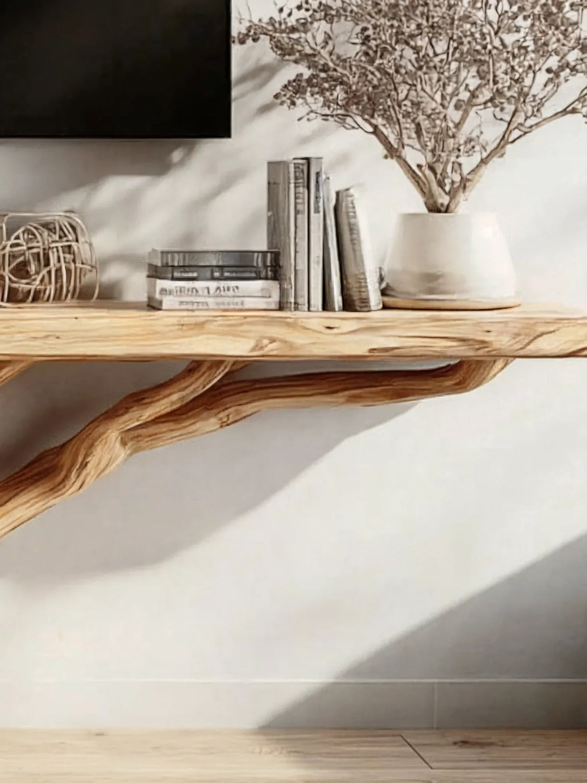 Minimalist interior with live edge wood floating shelf, books, decor, and potted plant