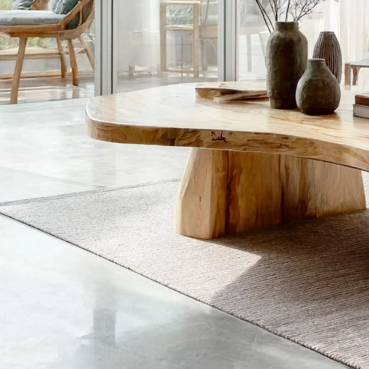 Minimalist living room with a live edge solid wood coffee table on a textured rug