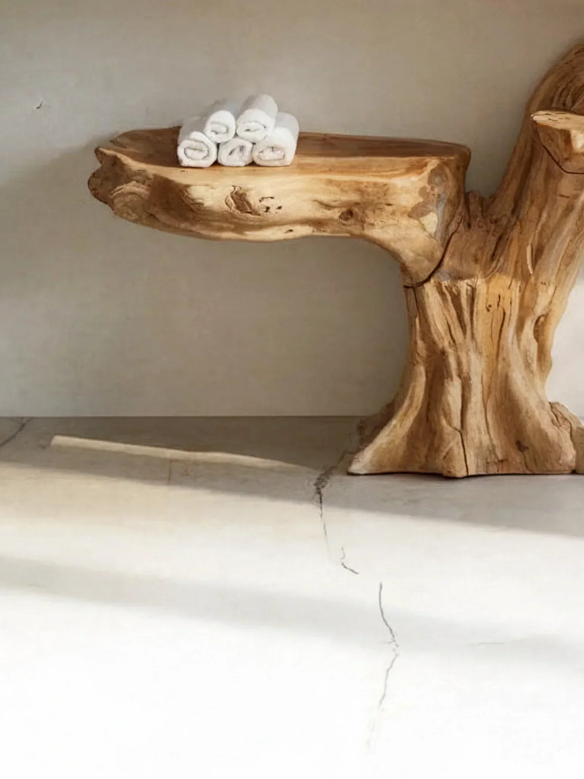 Live edge natural wood floating shelf with rolled white towels, rustic minimalist decor