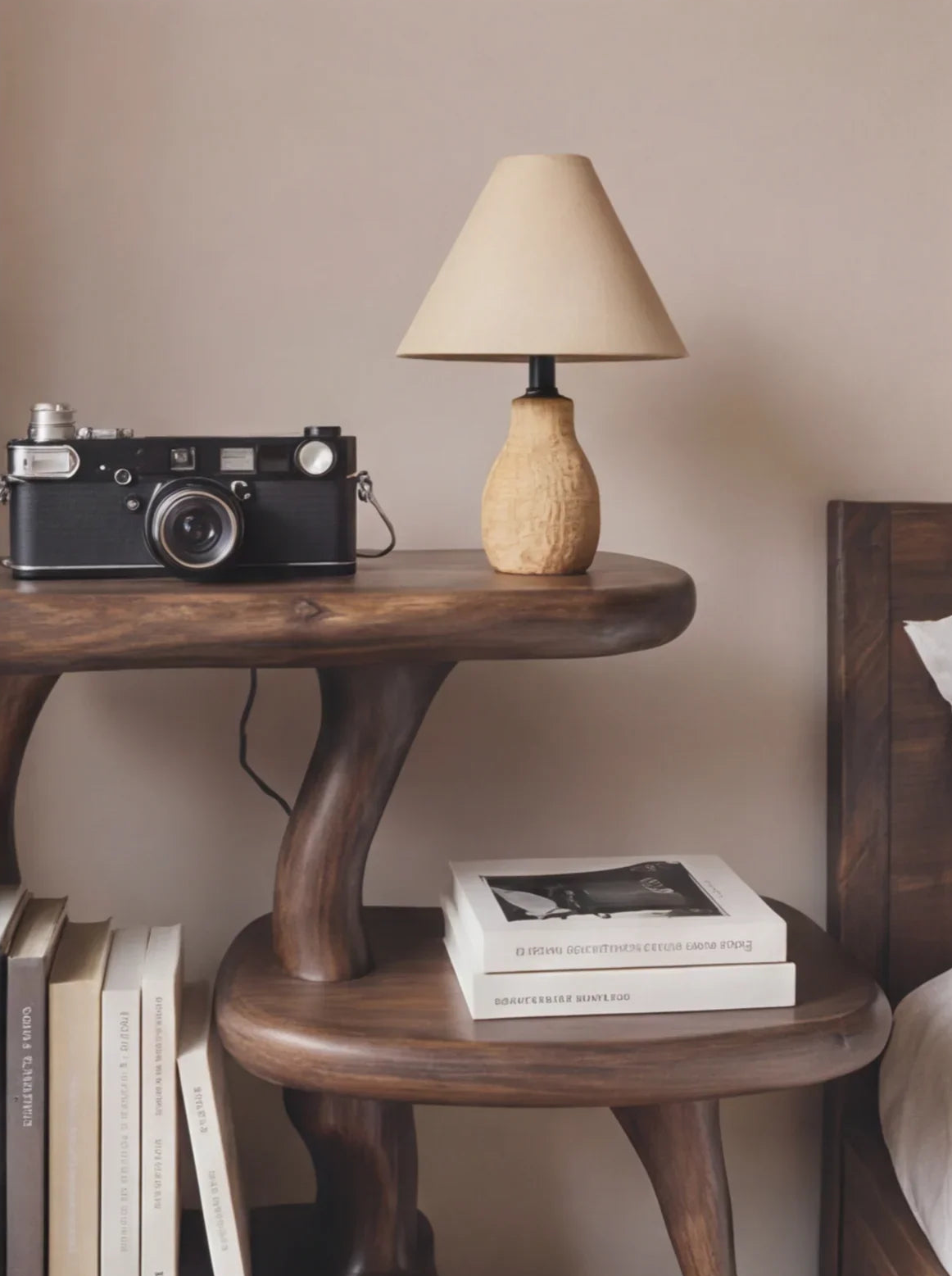 Solid wood live edge table with books, a vintage camera, and a small table lamp