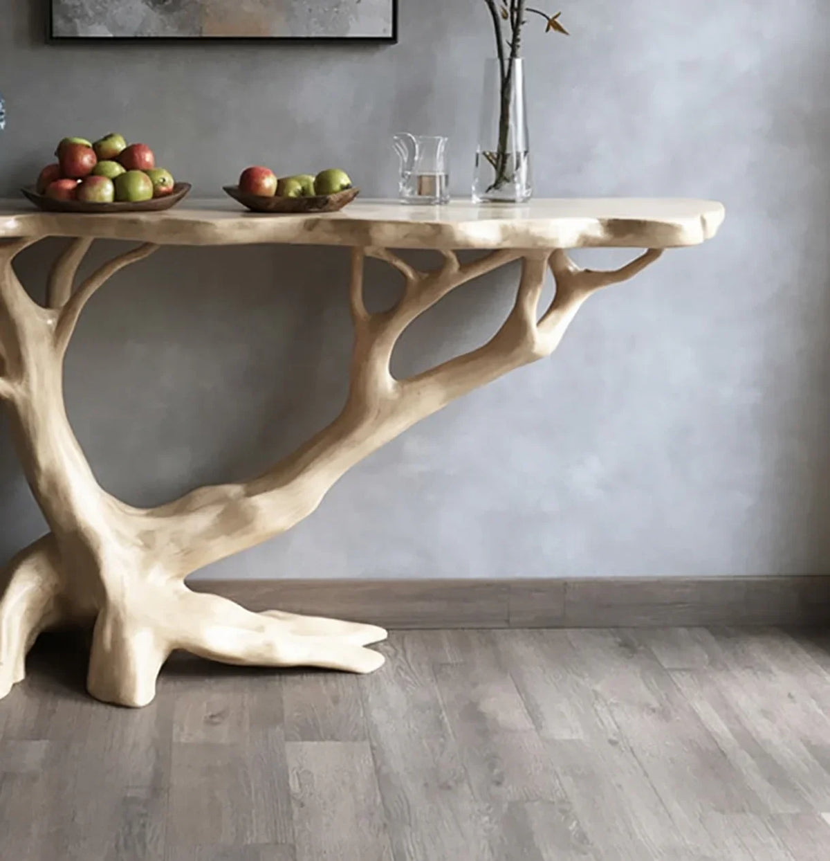 Live edge wood console table with tree-inspired base, topped with fruit bowls and a glass vase.