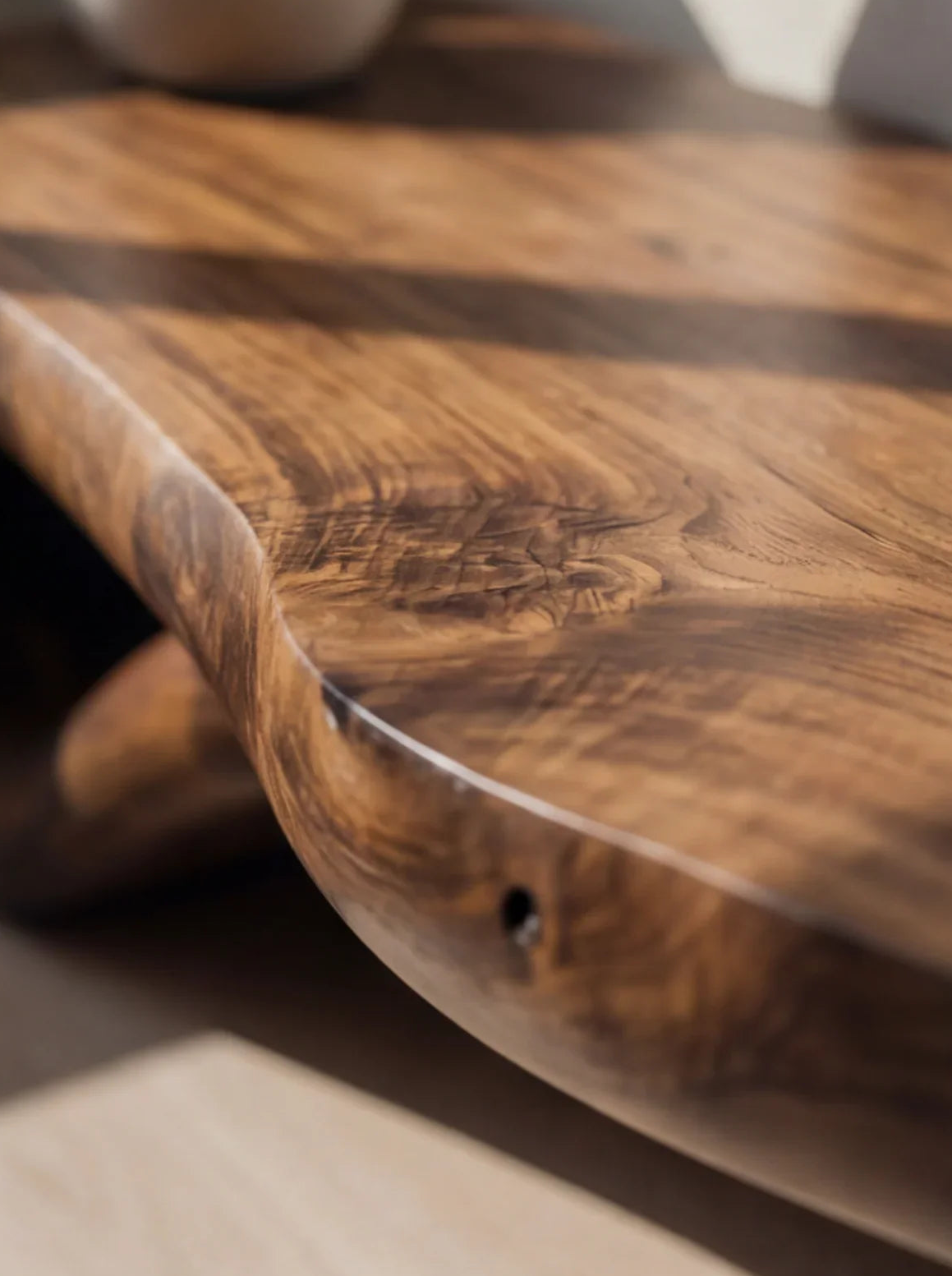 Close-up of live edge solid wood table with natural grain and smooth, organic finish