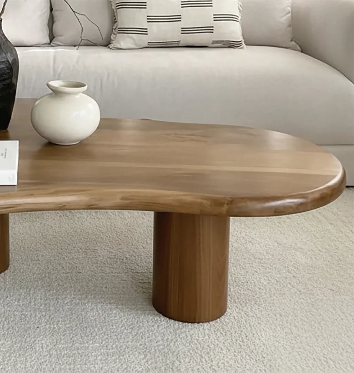 Solid wood live edge coffee table with rounded legs in modern living room setting