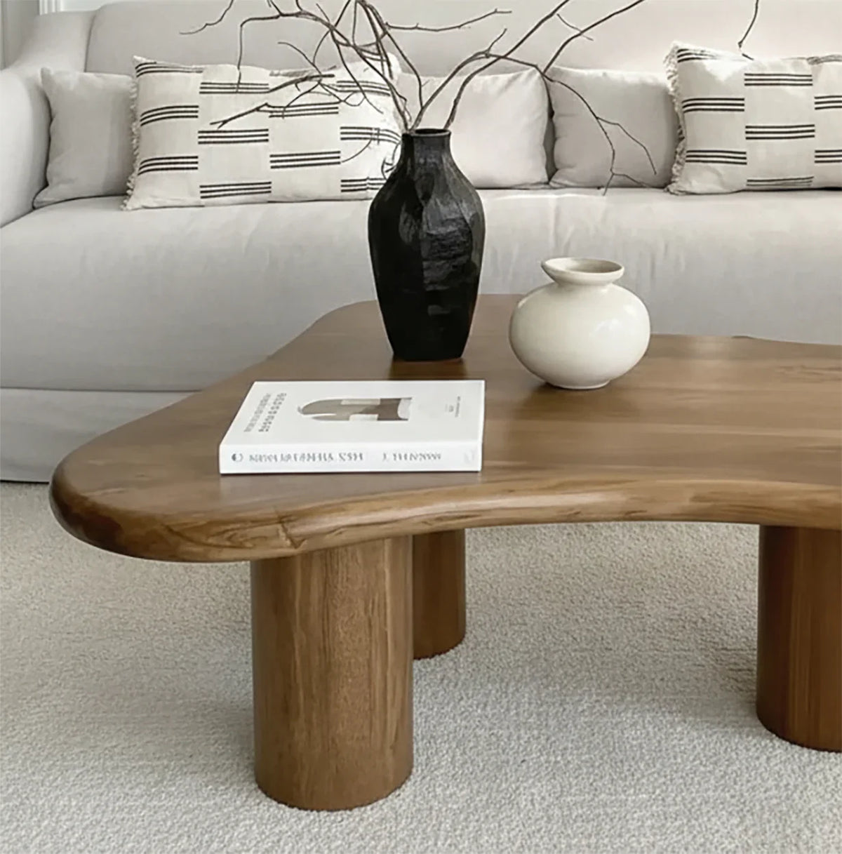Live edge solid wood coffee table with vases and book, in modern living room setting