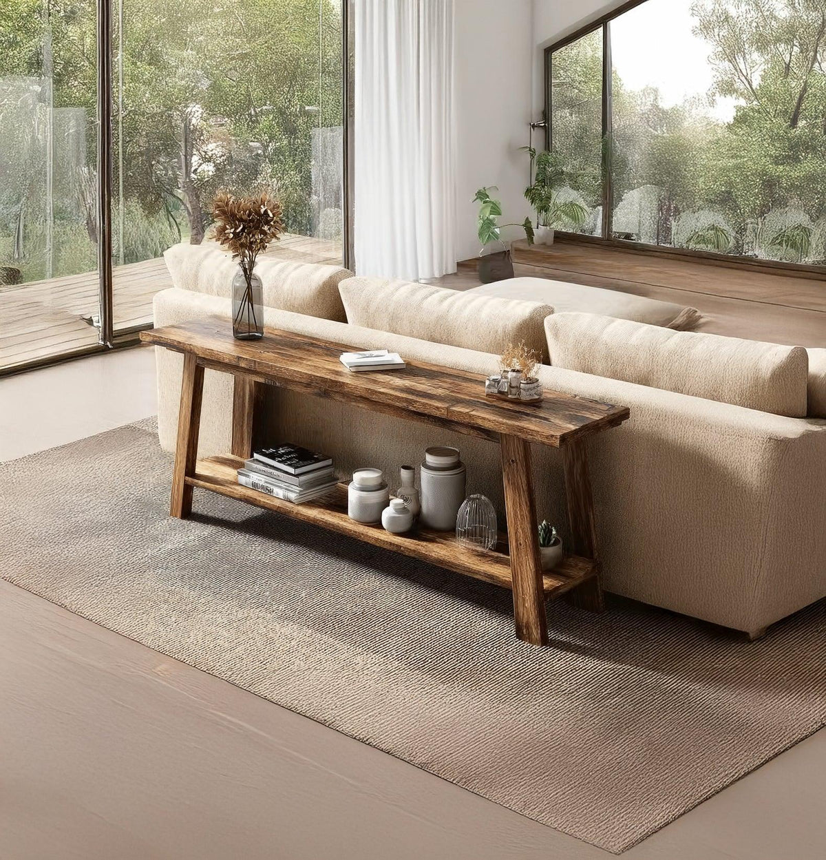 Modern living room with beige sofa, rustic wooden console table, decor jars, books, and large windows