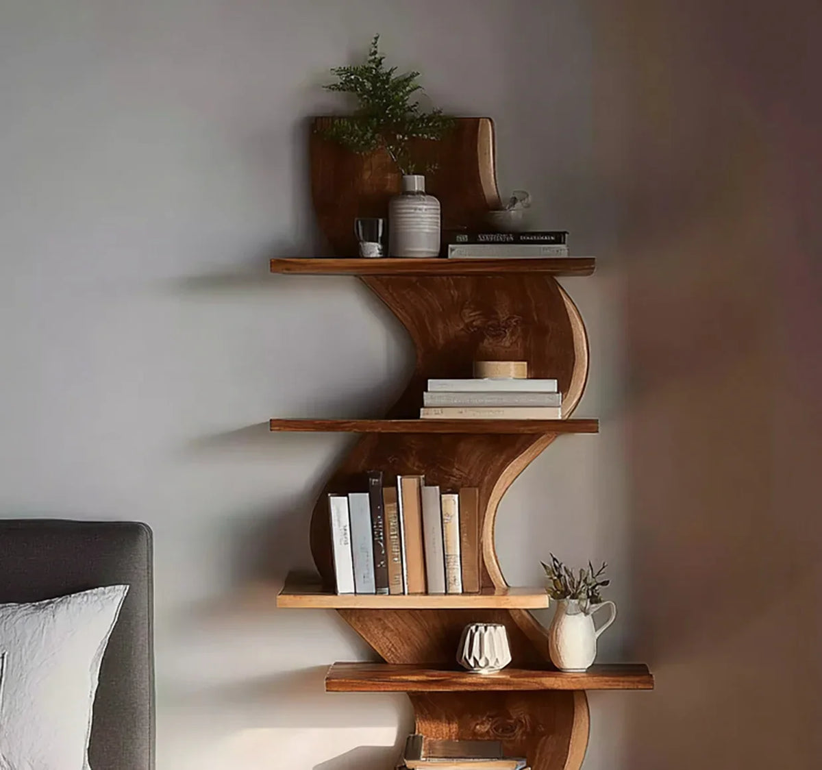 Live edge wooden bookshelf with curved design, decorated with books and ceramic vases