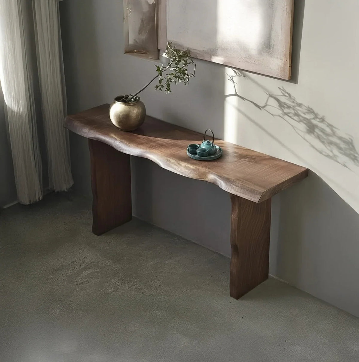 Live edge solid wood console table with decorative vase and tray in a minimalist room