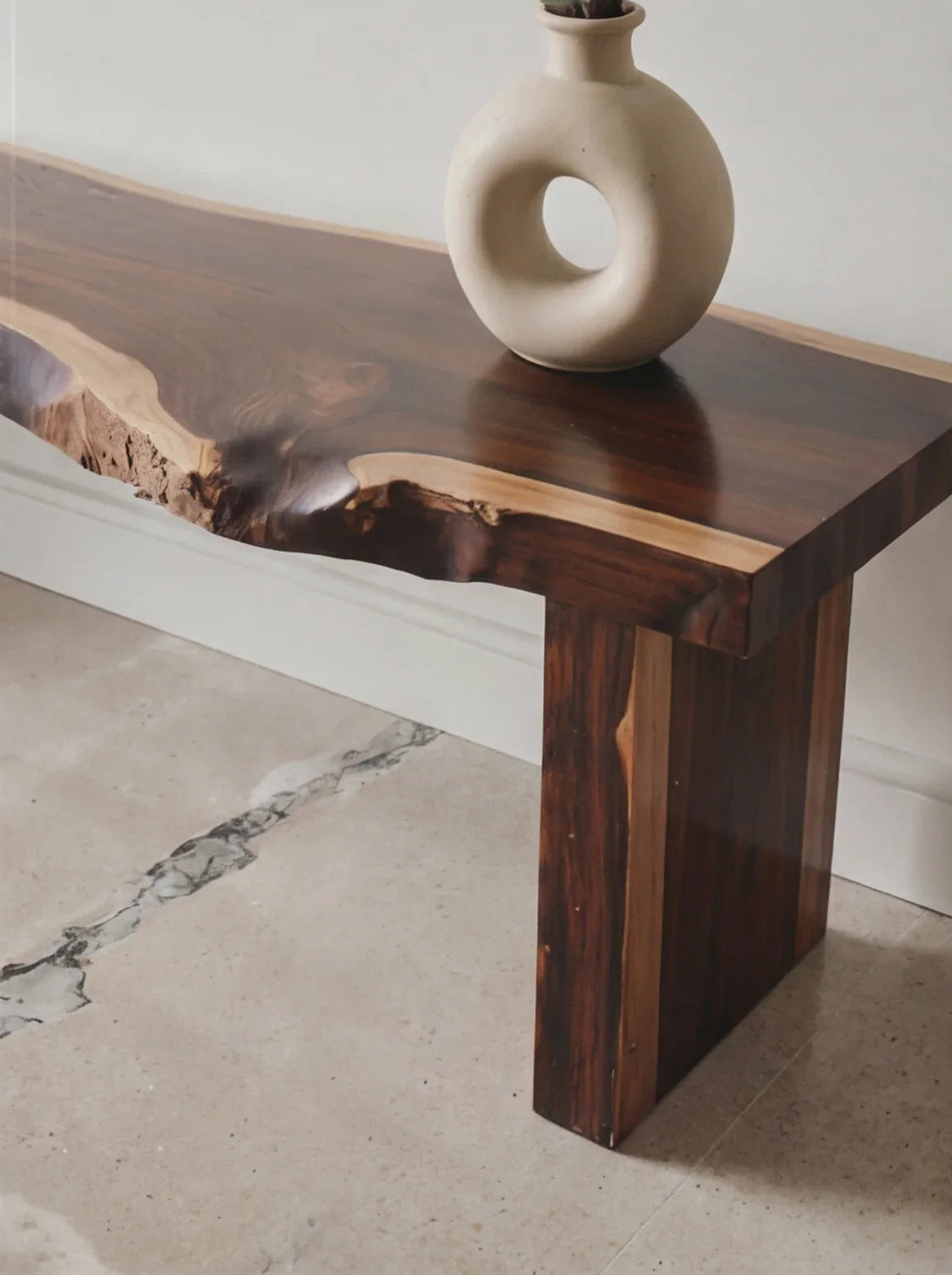 Live edge solid wood table with natural grain, topped with a round ceramic vase