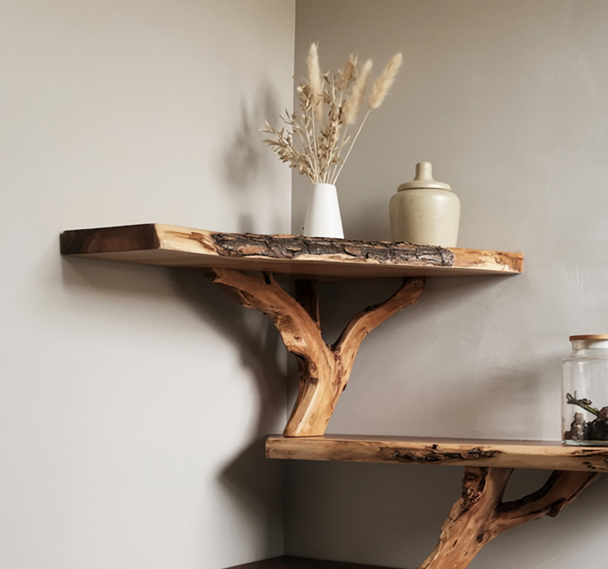 Rustic corner wooden shelves with natural bark edges, decorated with dried flowers and ceramic jar