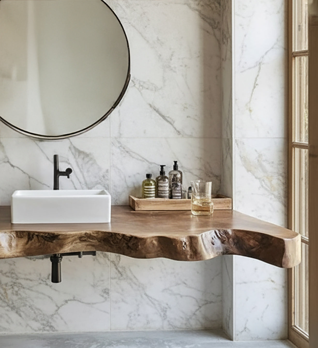 Modern bathroom with natural wood live edge countertop, white sink, black faucet, round mirror, and marble wall