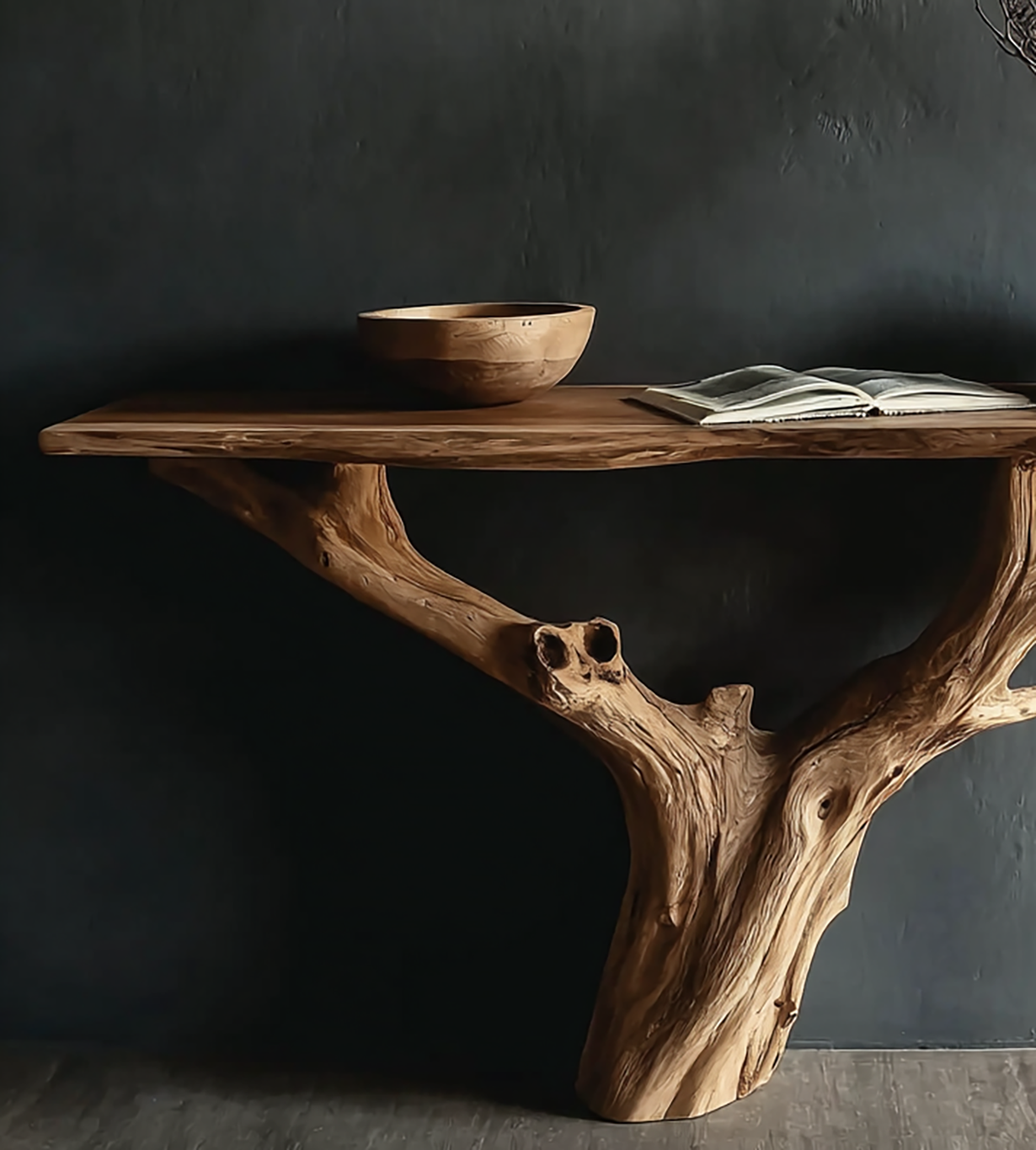 Rustic wooden console table with natural tree branch support, wooden bowl, and open book on dark wall