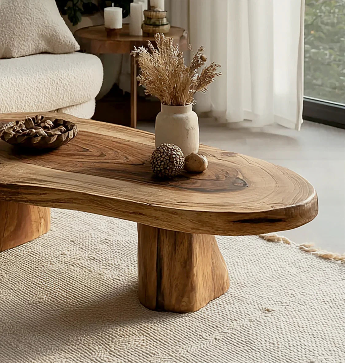 Natural wooden coffee table with dried flowers and decorative balls in a cozy living room