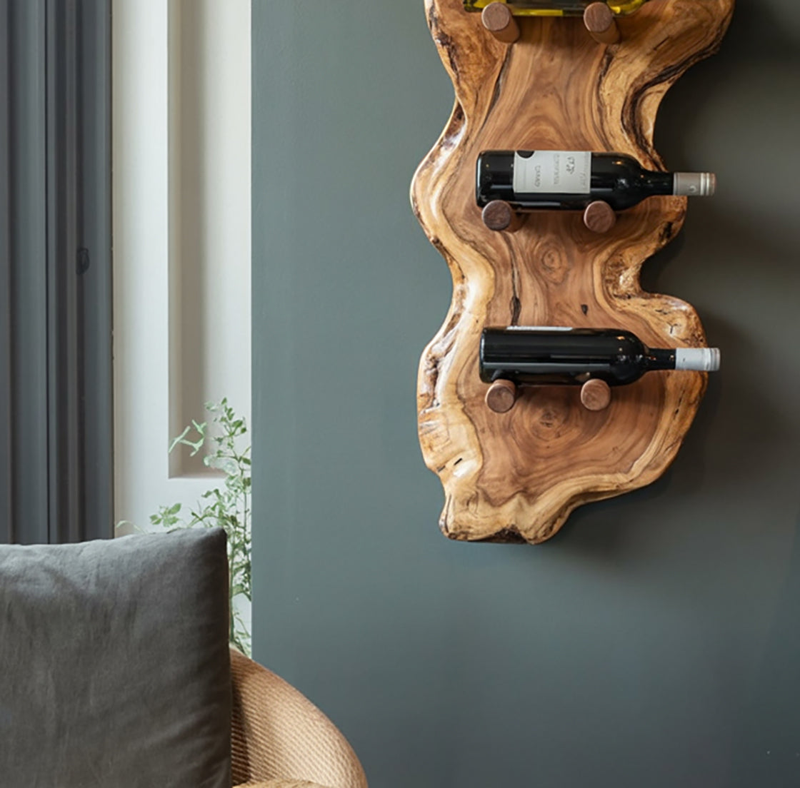 Rustic wooden wine rack mounted on gray wall with two bottles of red wine