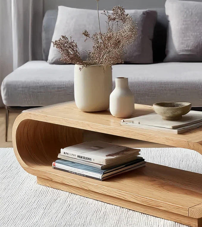 Modern wooden coffee table with books, ceramic vases, and a bowl in a cozy living room