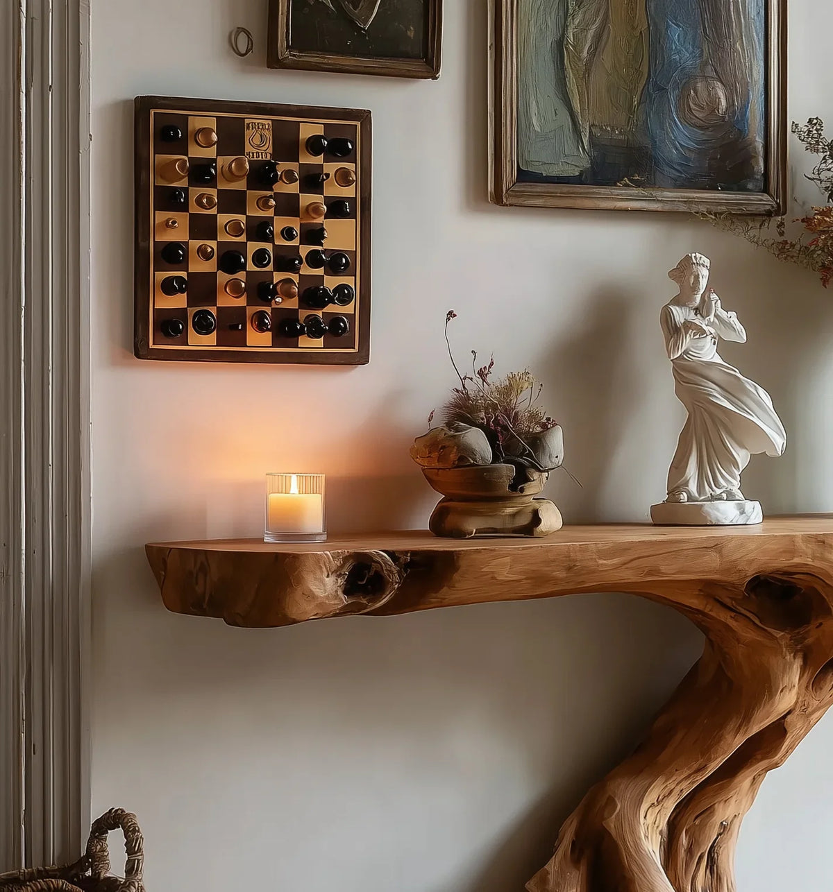 Live edge wooden console table with candle, statue, wall art, and chess board decor