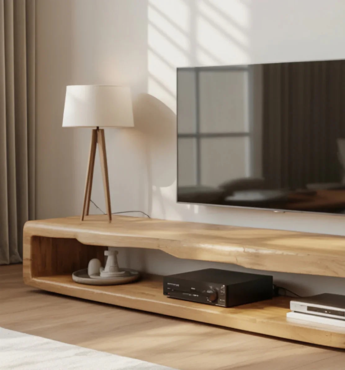 Modern wooden TV stand with a tripod floor lamp, flat-screen TV, and audio equipment in a minimalist living room