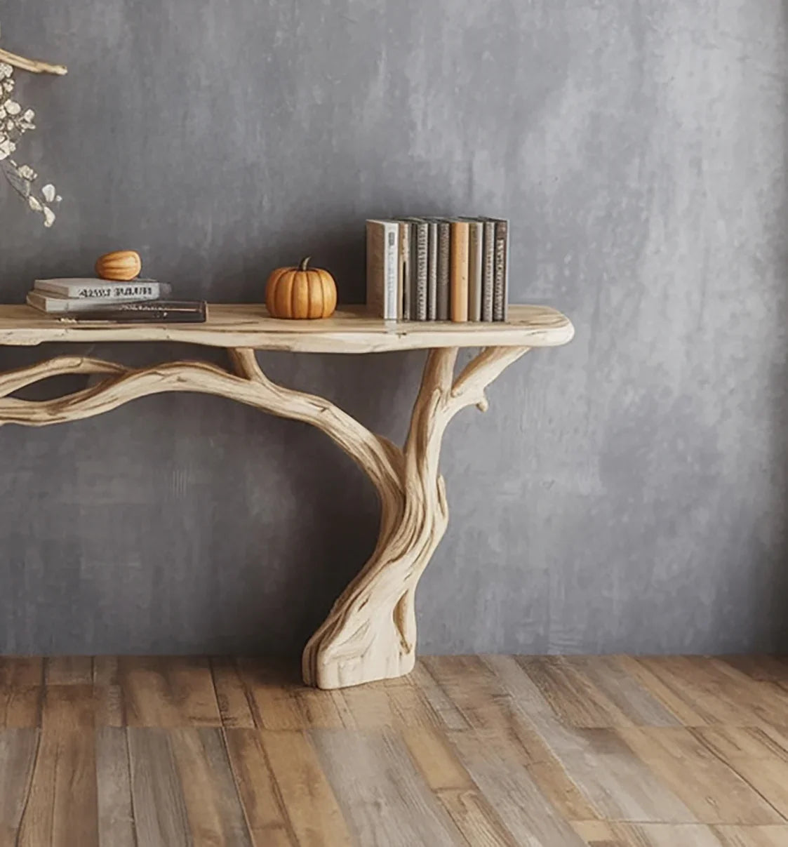 Rustic wooden table with natural branch-style legs, decorated with pumpkins and books against gray wall