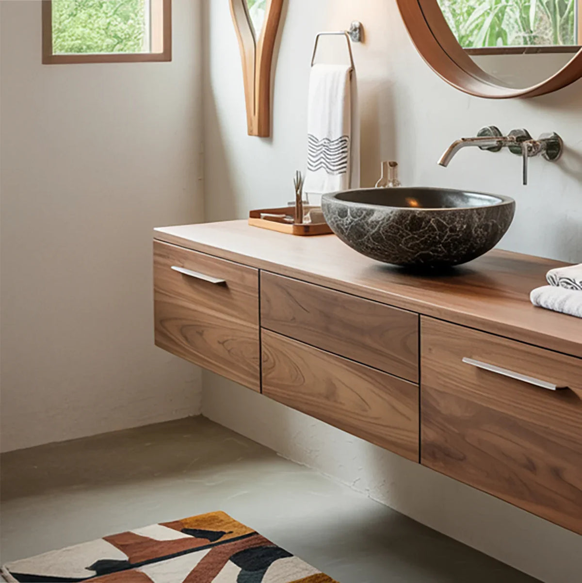 Modern bathroom with solid wood floating vanity, stone vessel sink, and round mirror