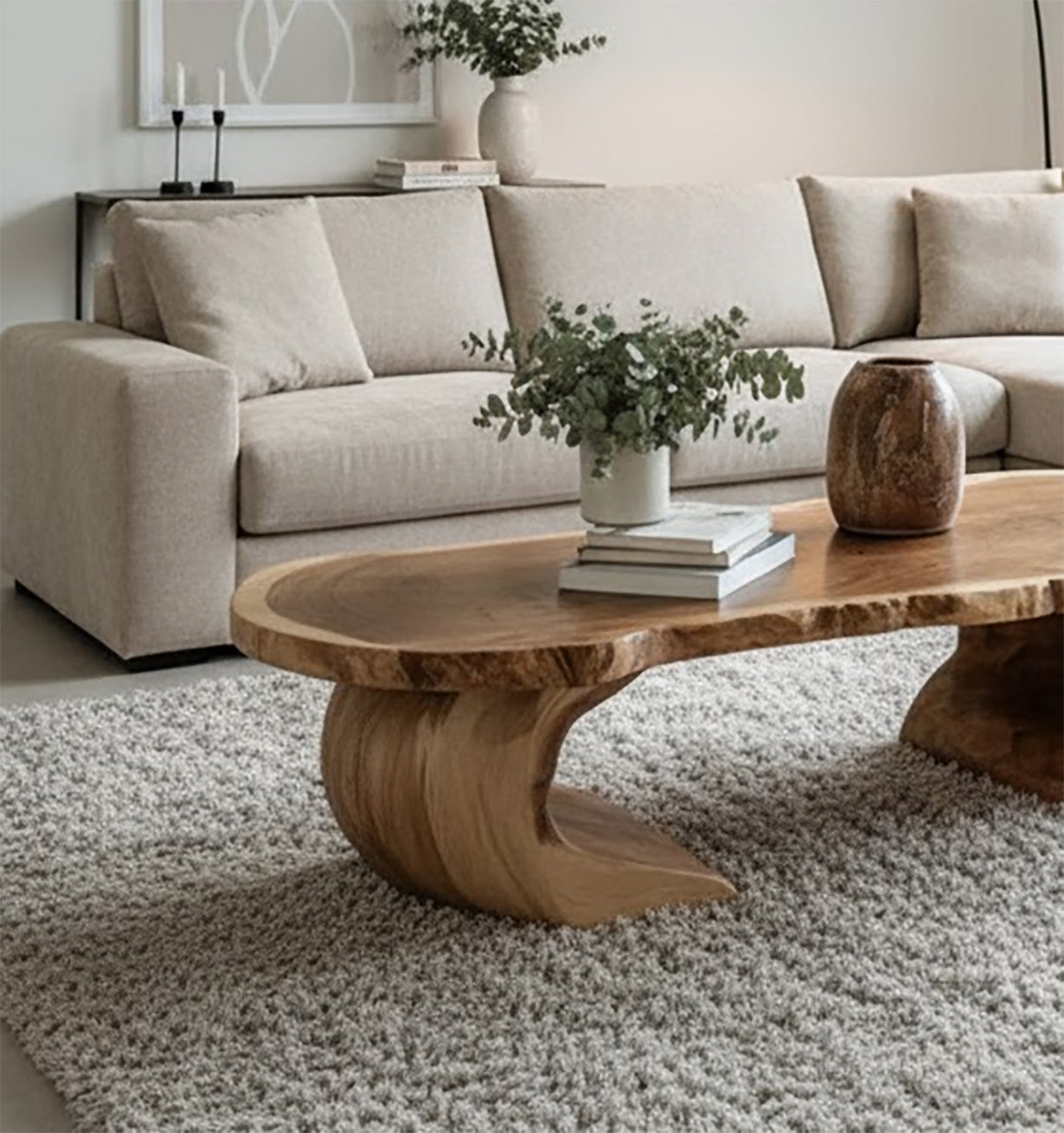 Modern beige sectional sofa with natural wood coffee table, green plant, and neutral decor in living room