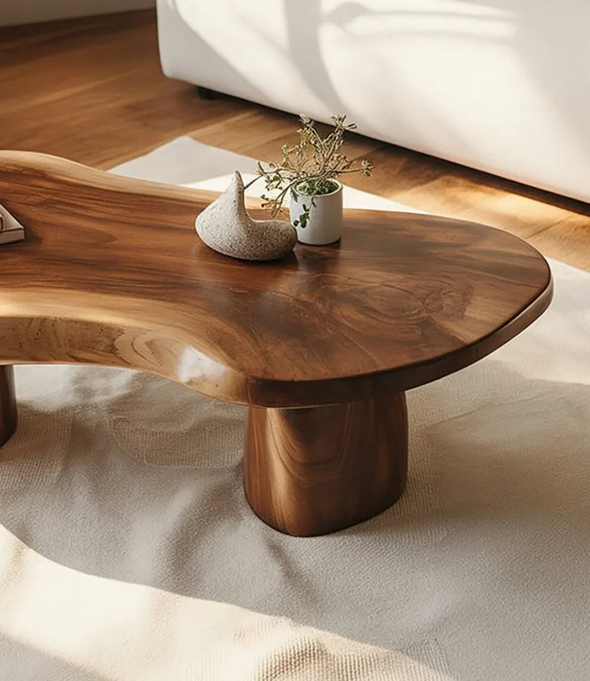Live edge solid wood coffee table with organic shape on beige rug in sunlit living room