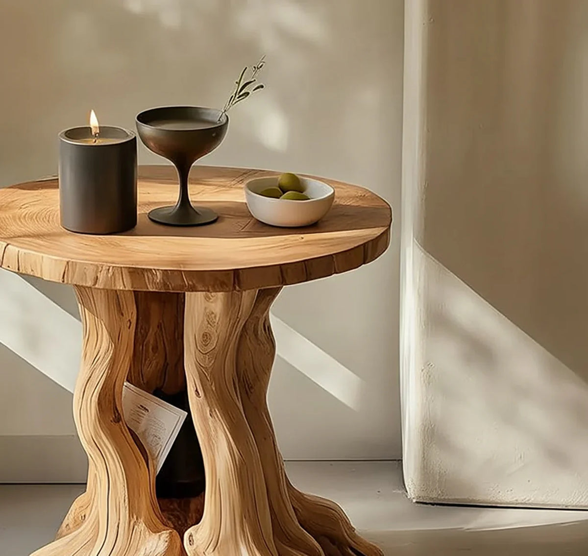 Live edge solid wood side table with sculpted base, candle, and bowl in sunlit room