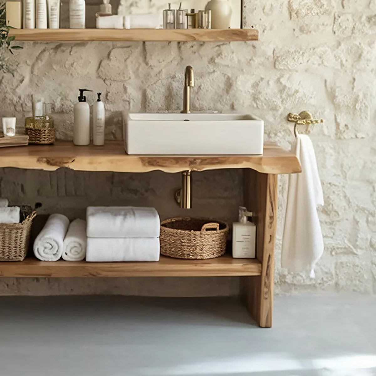 Live edge wood bathroom vanity with vessel sink, gold faucet, and woven baskets in rustic setting