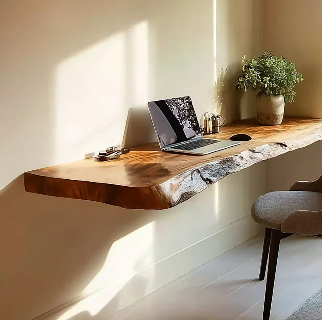 Live edge floating wood desk with laptop, mouse, potted plant, and chair in modern home office