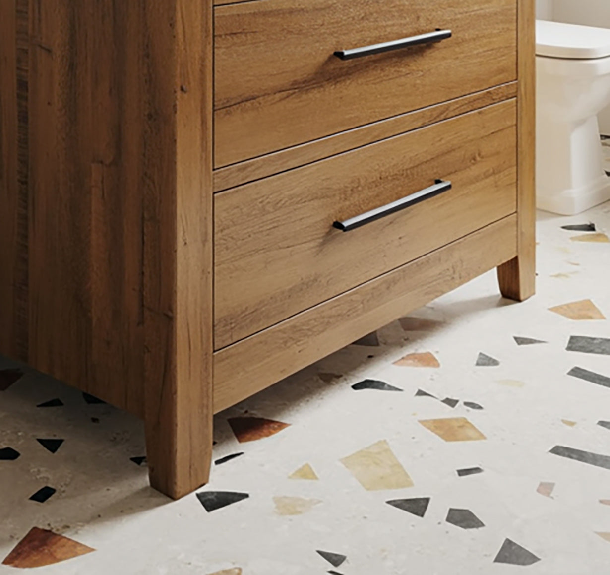 Solid wood dresser with black handles on terrazzo tile floor in modern bathroom