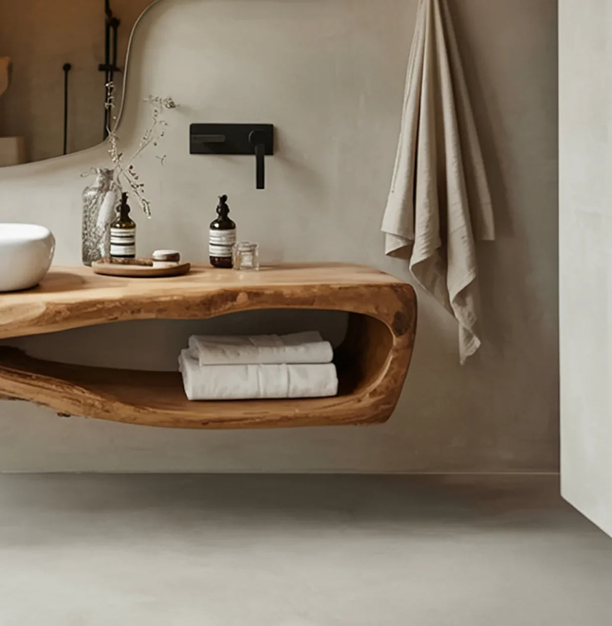 Modern bathroom with natural wood floating vanity, white vessel sink, black faucet, and beige towels