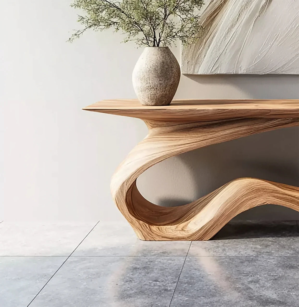 Curved wooden console table with natural grain and a ceramic vase holding greenery on top