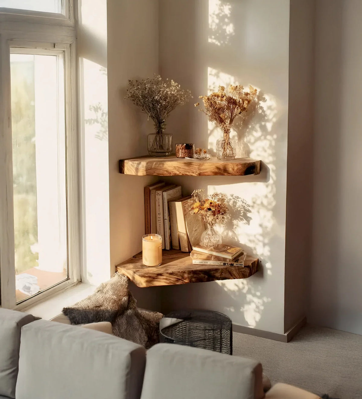 Cozy corner with two rustic wooden wall shelves holding dried flowers jars, books, and a lit candle