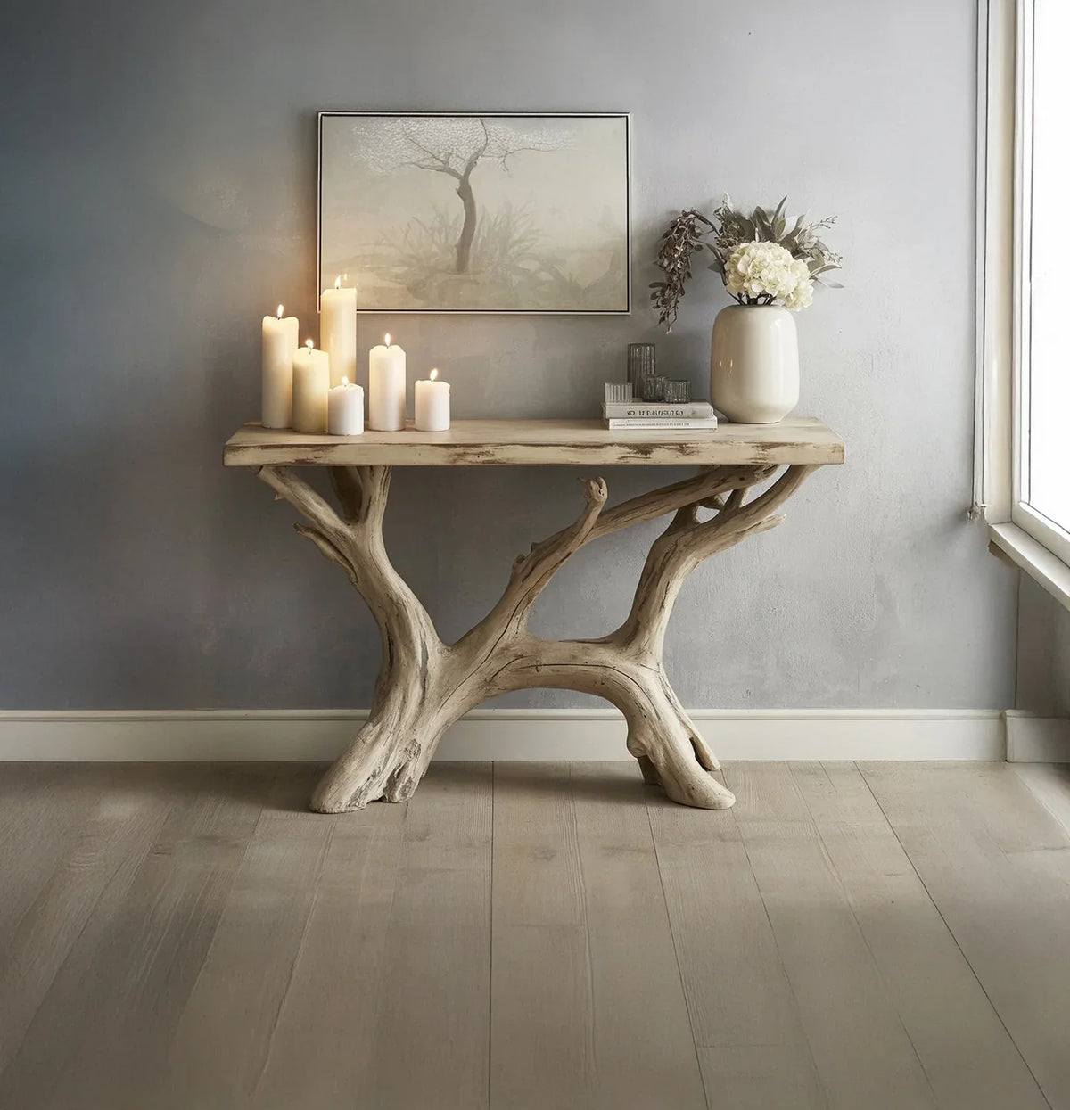 Rustic wooden console table with asymmetrical branch legs, decorated with lit candles, vase, and wall art