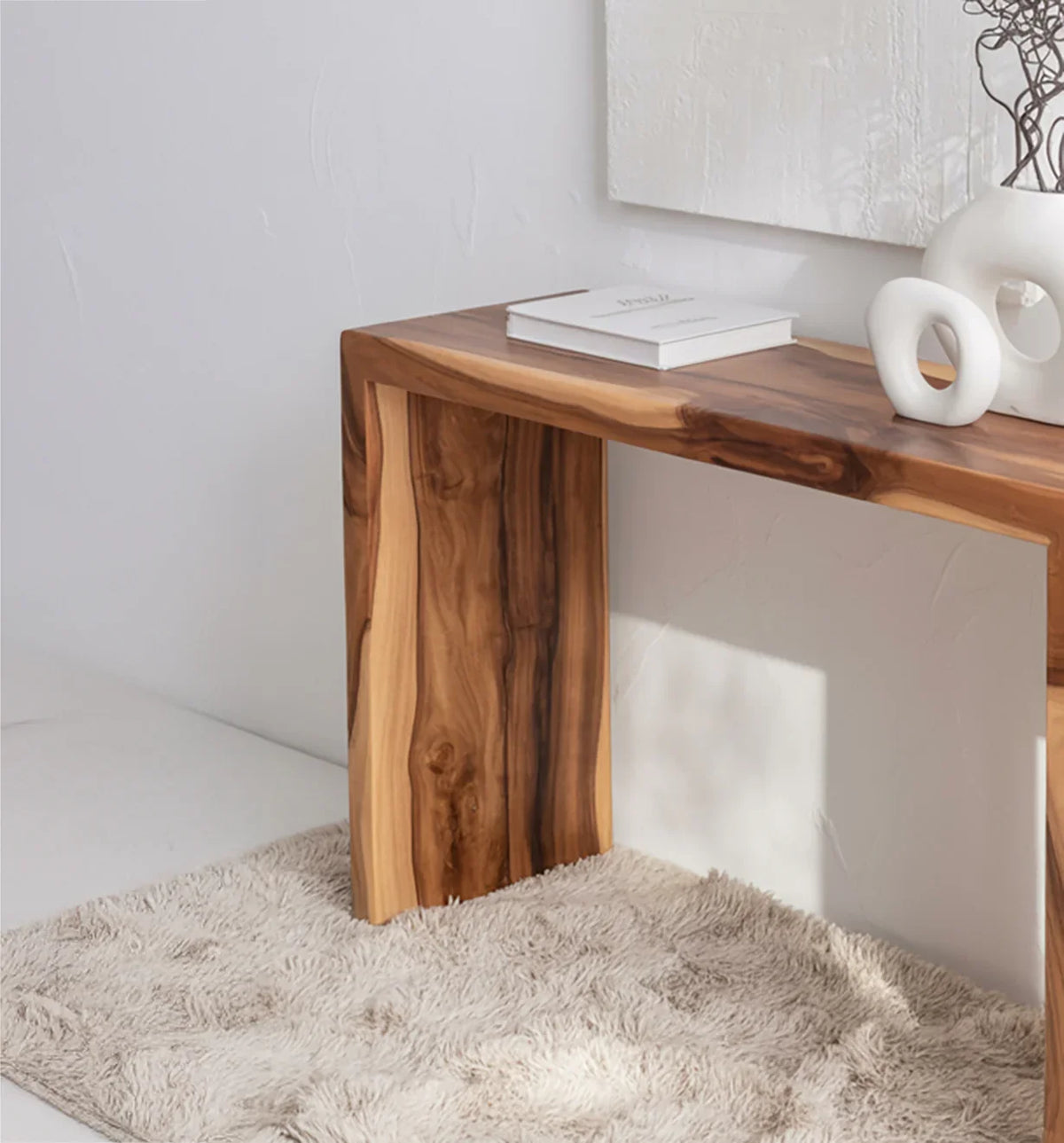 Solid wood live edge console table with natural grain, styled on a beige rug in a modern room