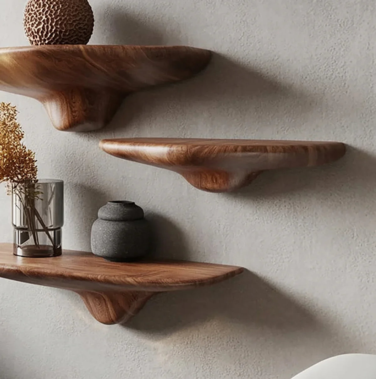 Solid wood live edge floating shelves mounted on a textured gray wall with minimalist decor