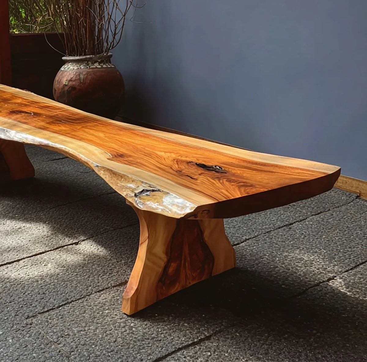 Live edge solid wood table with natural finish, unique grain, in a modern indoor setting.