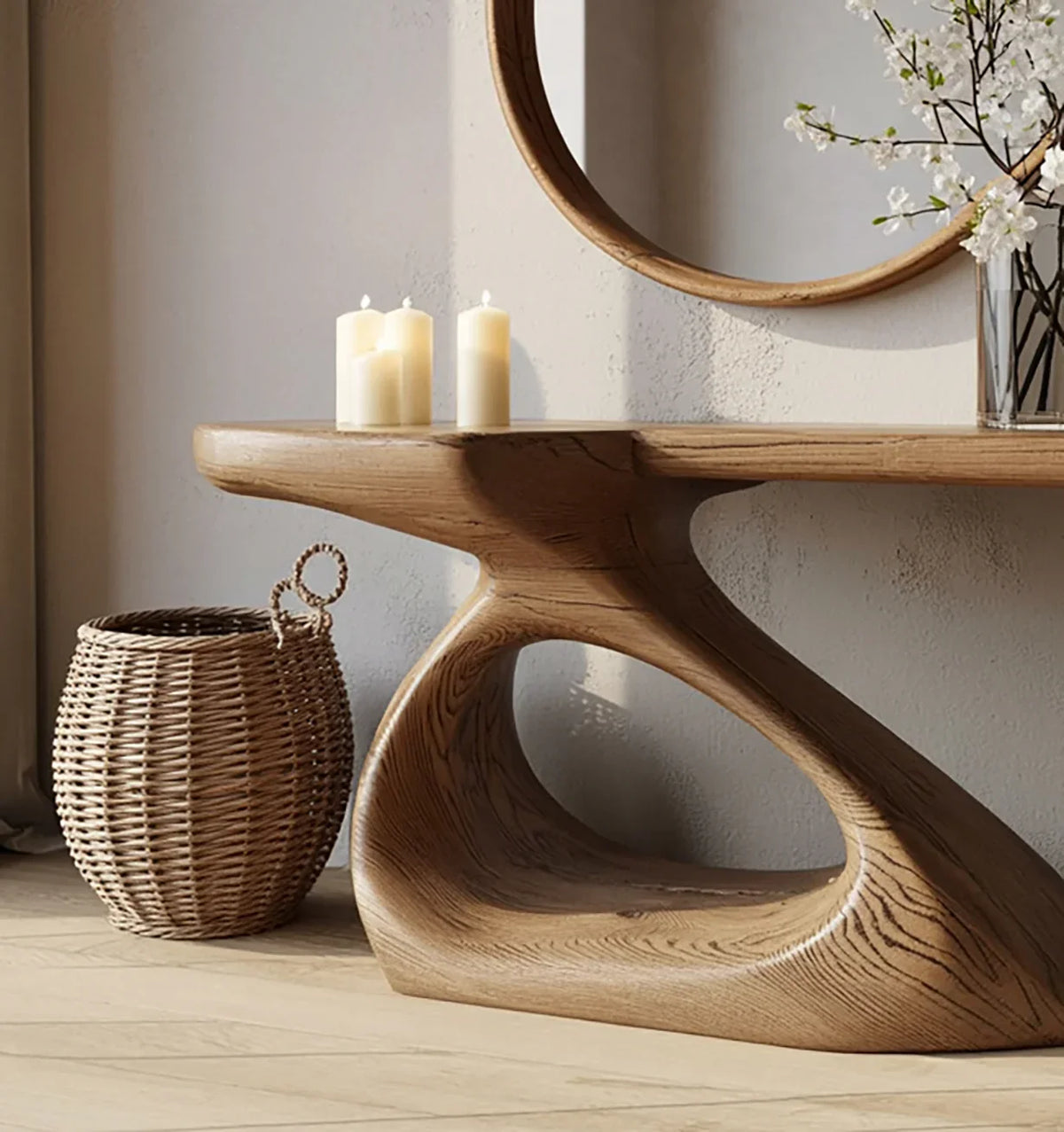 Modern wooden console table with sculptural base, lit candles, wicker basket, and round wall mirror