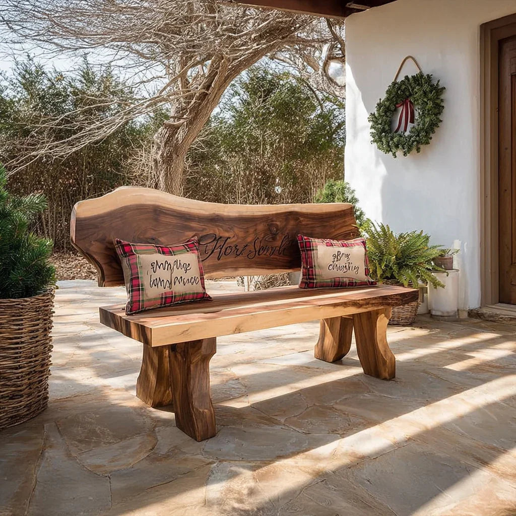Rustic live edge wooden bench with plaid pillows on stone patio beside festive green wreath on white wall