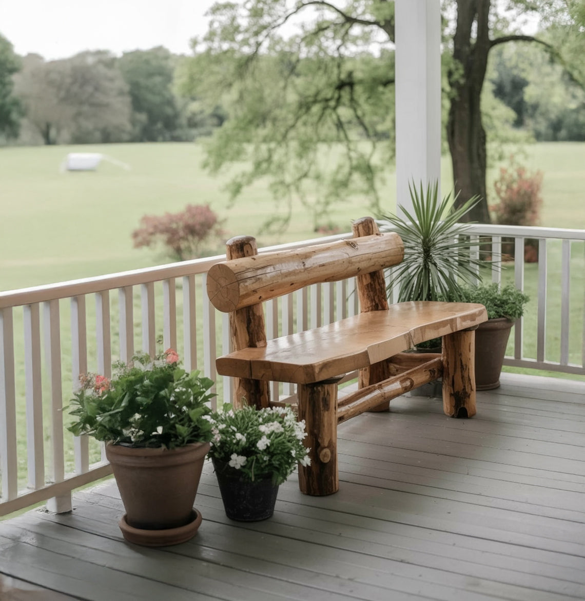 Rustic wooden bench on porch surrounded by potted plants with green outdoor landscape