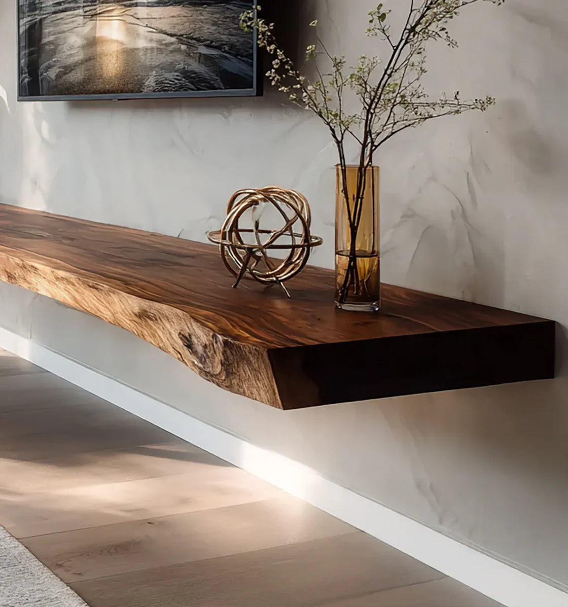 Floating live edge wooden shelf with decorative metal orb and amber vase with branches