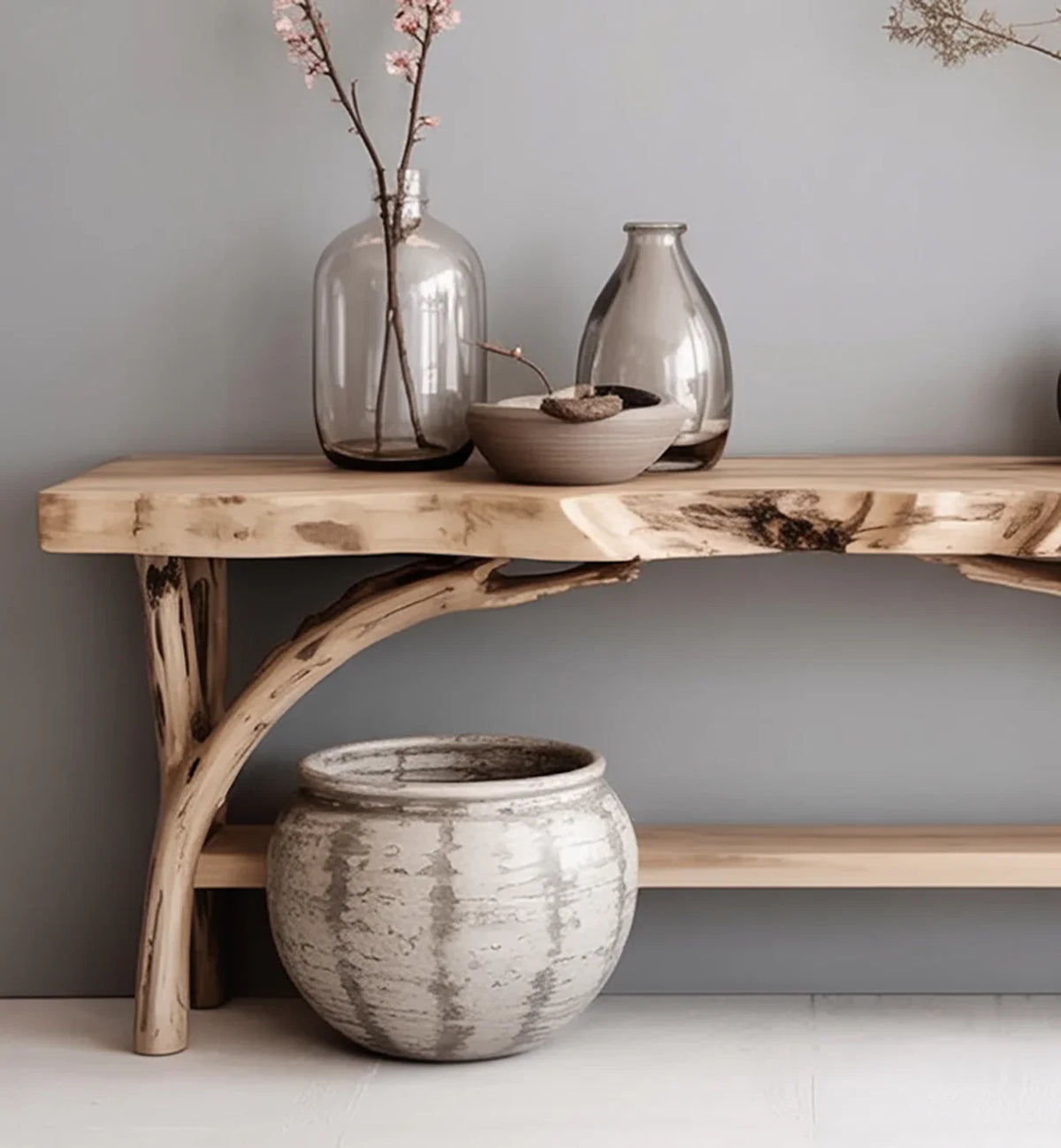 Live edge solid wood console table with decorative vases and a large ceramic pot