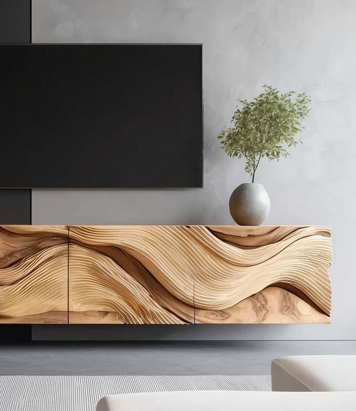 Sculpted solid wood cabinet with wave pattern in modern living room, round vase with plant on top.