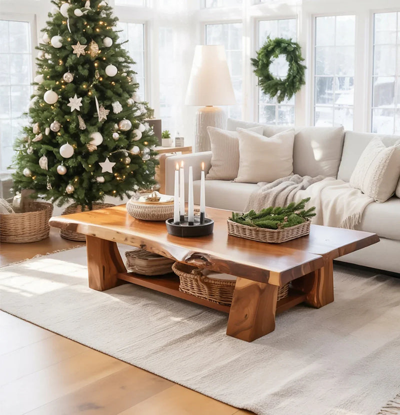 Cozy living room with decorated Christmas tree, wooden coffee table with candles and greenery, and beige sofa