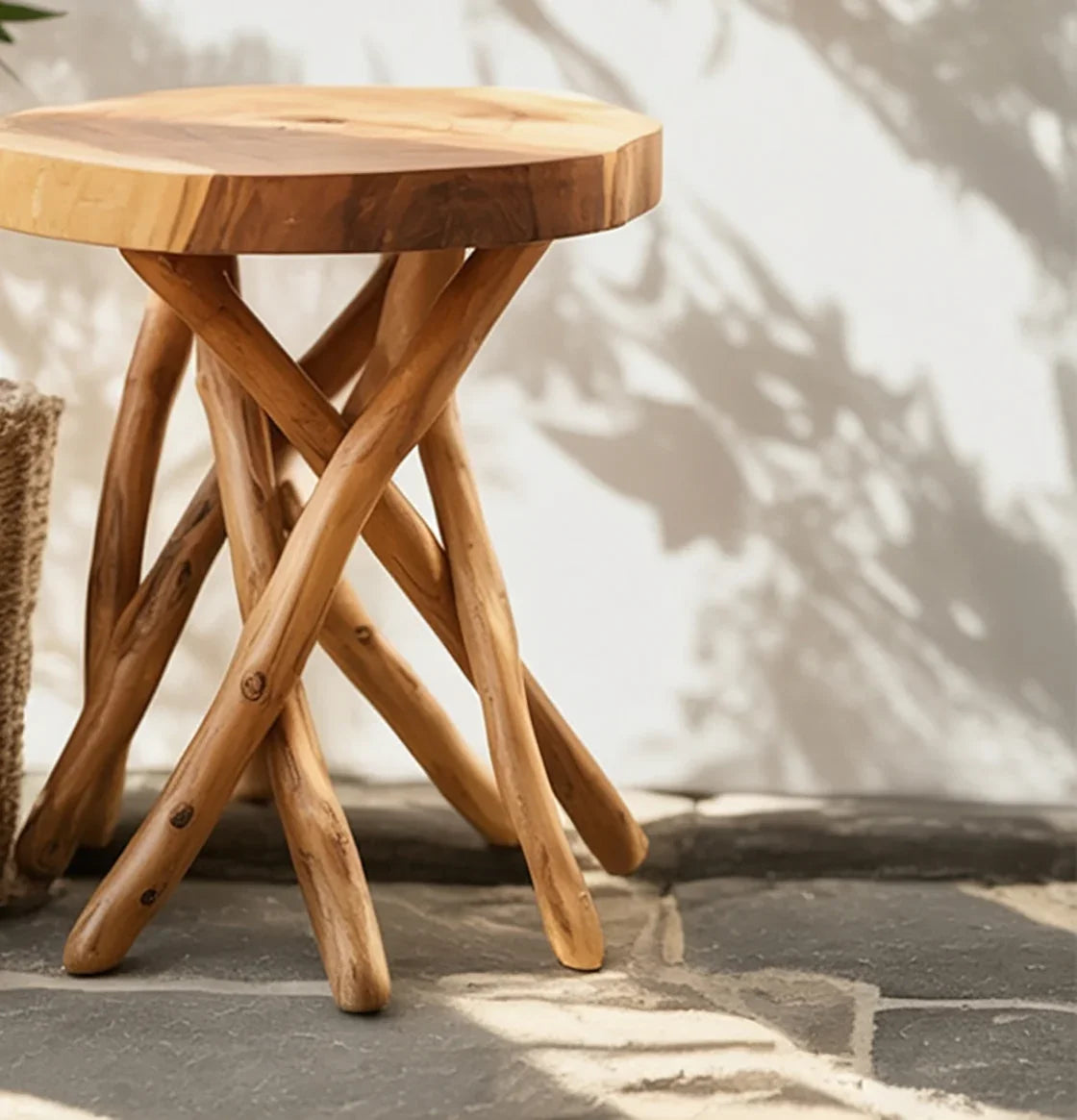 Rustic wooden side table with natural twisted branches base on stone floor with shadow on white wall