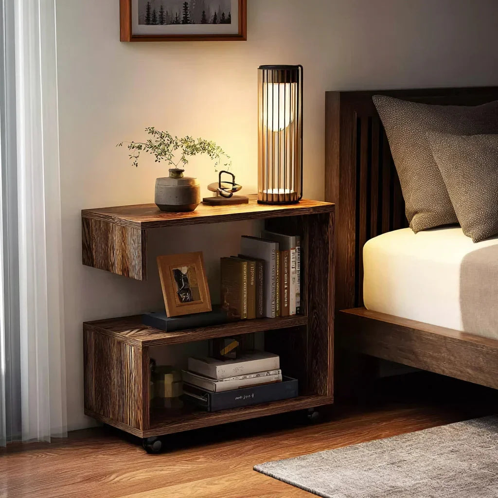 Modern wooden nightstand with books, decorative lamp, and plant beside a bed