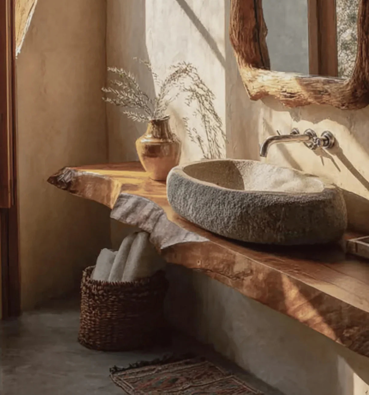 Rustic bathroom with stone sink, live edge wood countertop, decorative vase, woven basket with towels