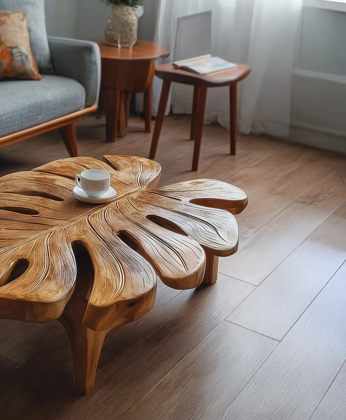 Solid wood coffee table shaped like a leaf in a modern living room with a cup on top